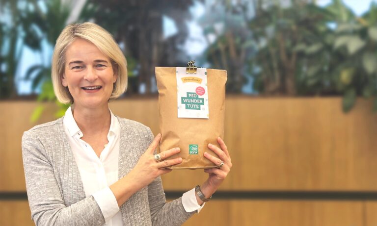 Lächelnde Frau, die eine PSD-Wundertüte in den Händen hält.